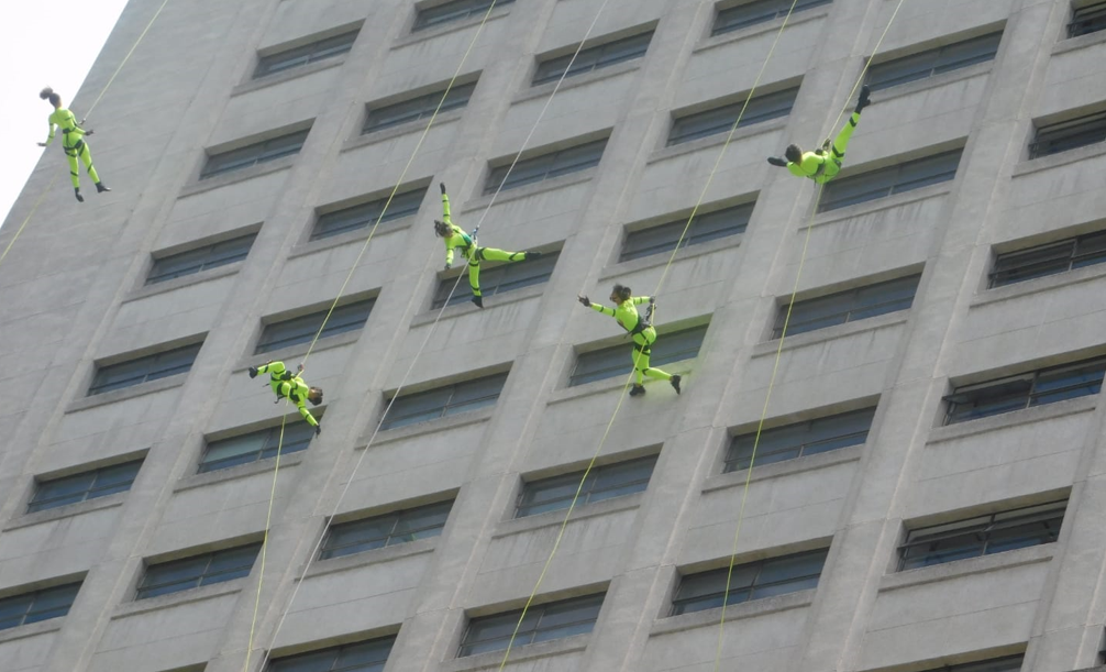 Shopping Leblon se prepara para o Rio Open com bailarinos suspensos na fachada para uma partida de tênis coreografada 