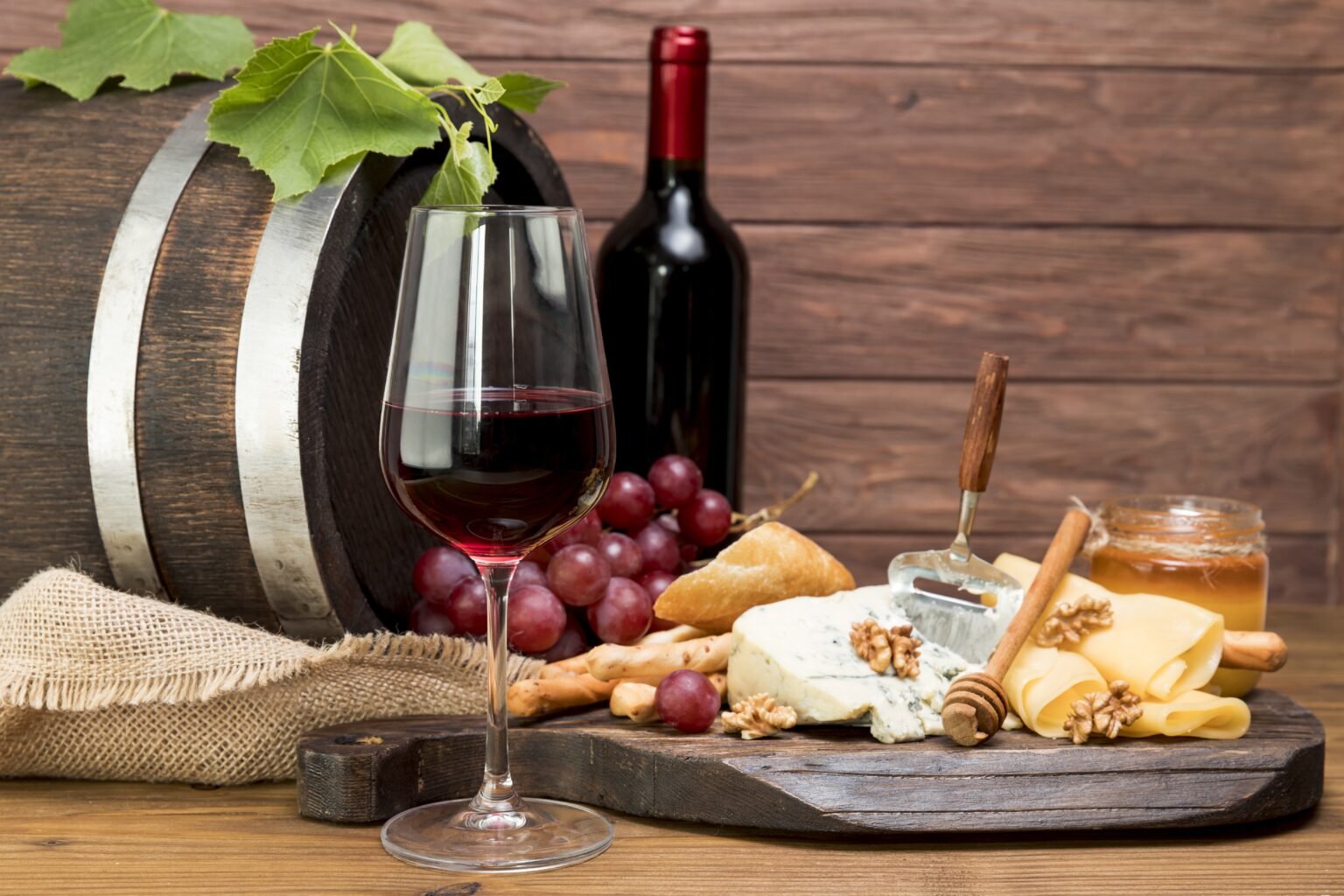 barril de madeira ao lado de vinho e tapa