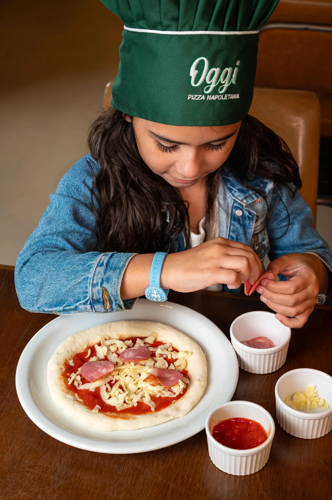 Crianças assumem a bancada e finalizam a própria massa em pizzaria